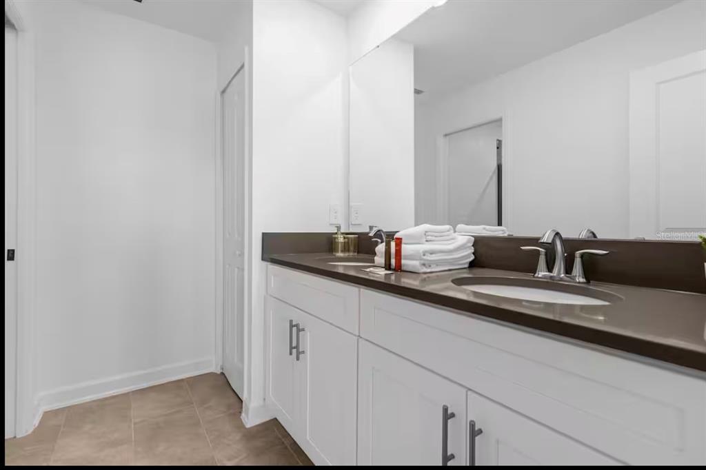 2992 Penelope Loop Kissimmee, FL 34746 - Photo 53 of 83 a bathroom with a granite countertop sink and a mirror