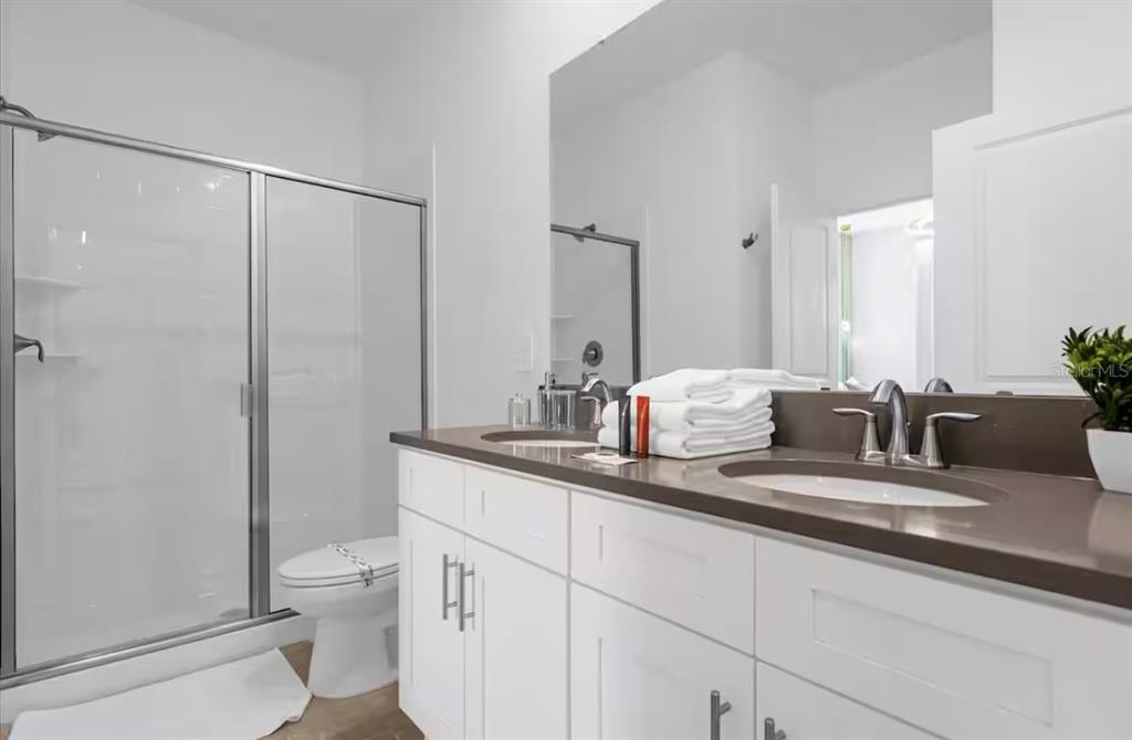 2992 Penelope Loop Kissimmee, FL 34746 - Photo 56 of 83 a bath room with a toilet a sink and a mirror