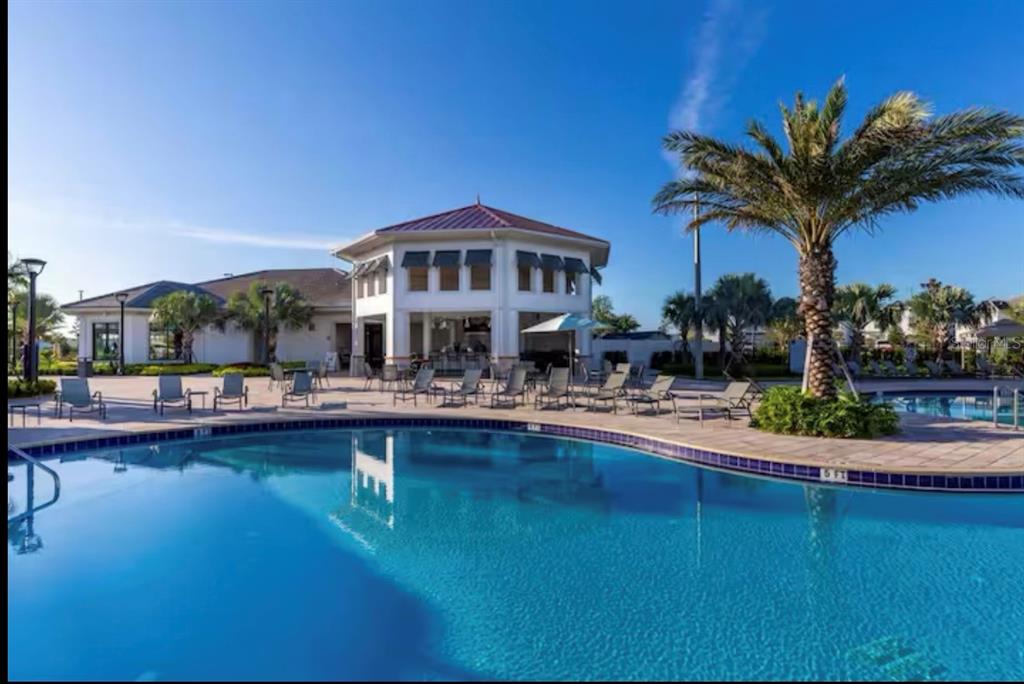2992 Penelope Loop Kissimmee, FL 34746 - Photo 67 of 83 a front view of a house with swimming pool having outdoor seating