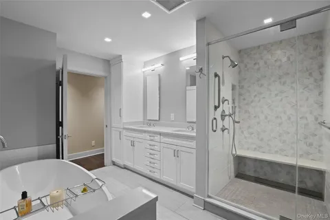 a bathroom with a tub sink and mirror