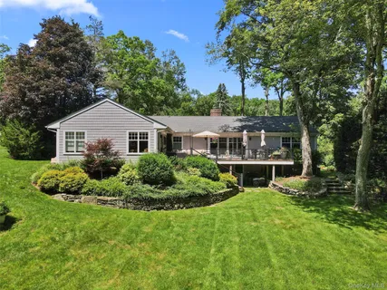 a house with green field in front of it