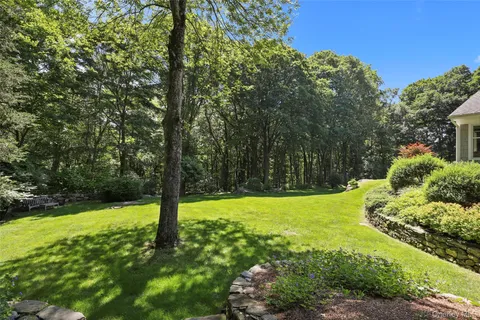 a house is sitting in middle od the grass