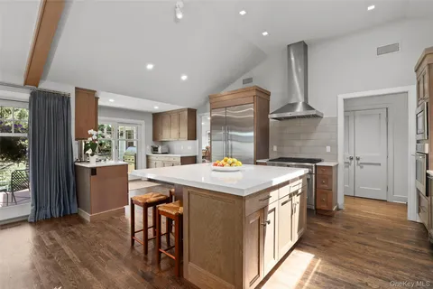 a kitchen with kitchen island a stove a table and chairs