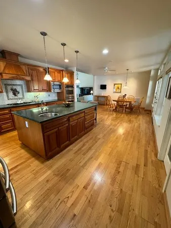 a kitchen with stainless steel appliances granite countertop a stove and a wooden floors