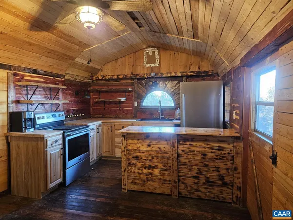 a kitchen with stainless steel appliances kitchen island wooden cabinets and a stove
