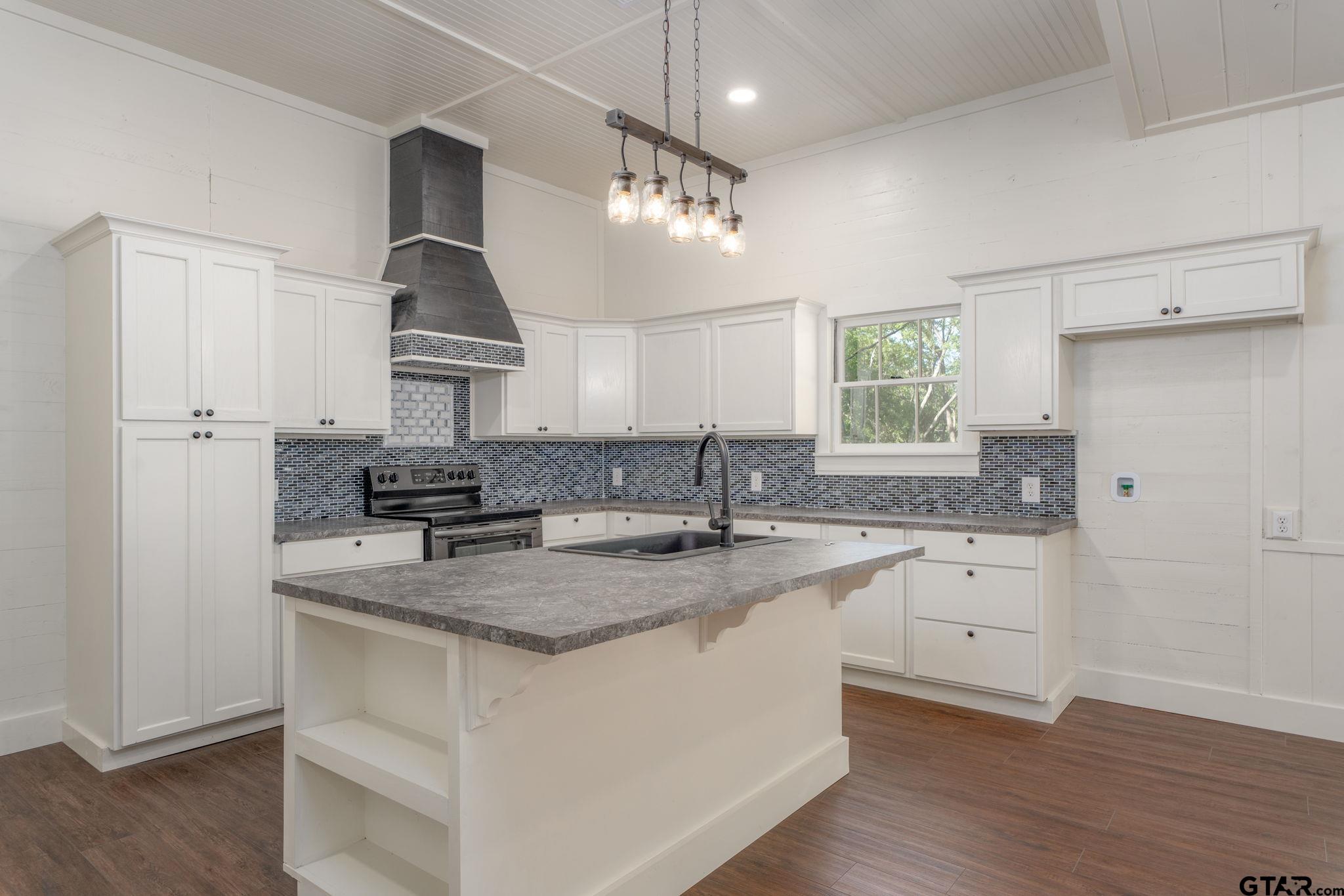605 East Calvert Street Troup, TX 75789 - Photo 11 of 23 a kitchen with granite countertop a sink a counter space appliances and cabinets