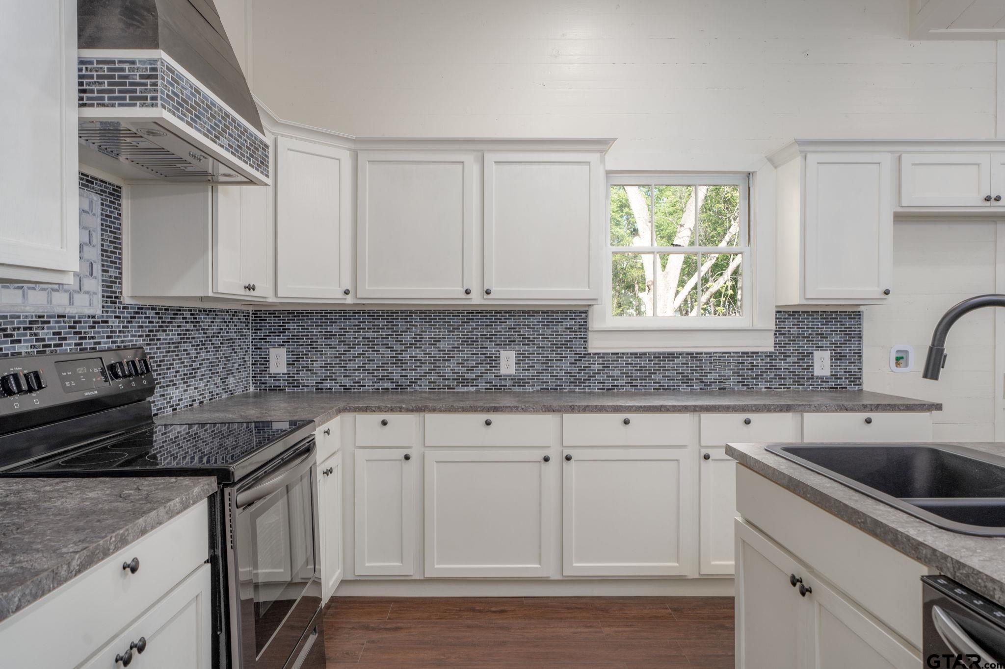 605 East Calvert Street Troup, TX 75789 - Photo 12 of 23 a kitchen with stainless steel appliances granite countertop a sink stove and cabinets