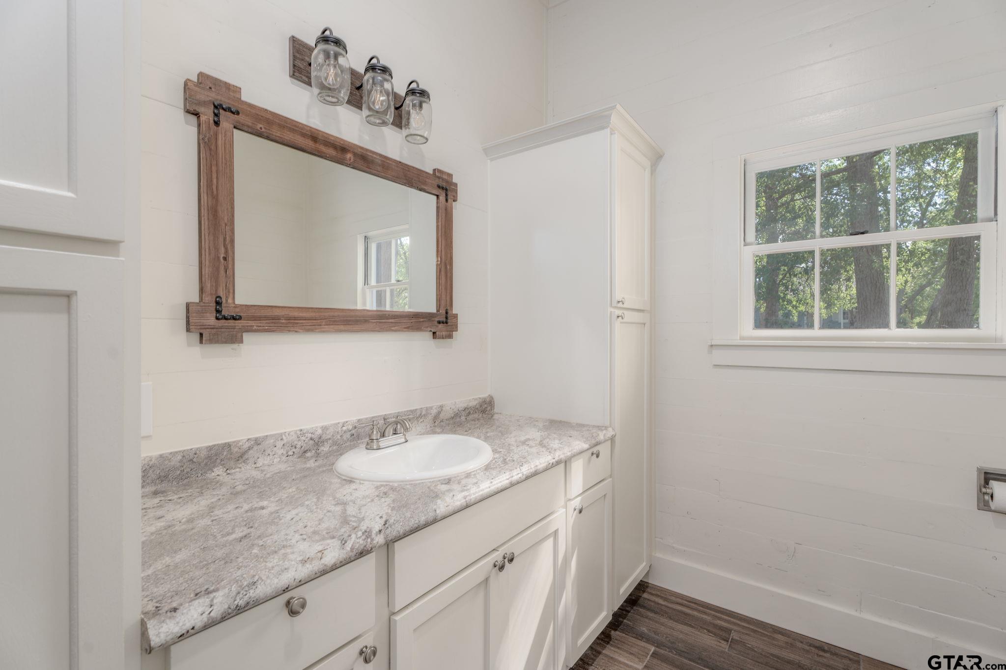 605 East Calvert Street Troup, TX 75789 - Photo 14 of 23 a bathroom with a sink vanity and a mirror