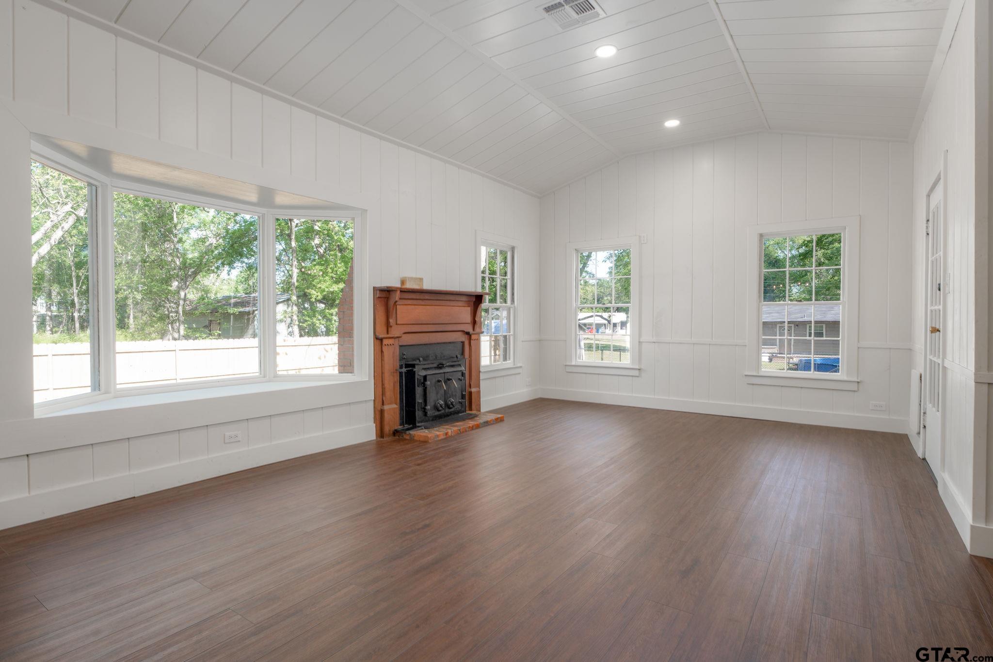 605 East Calvert Street Troup, TX 75789 - Photo 7 of 23 an empty room with windows and fireplace
