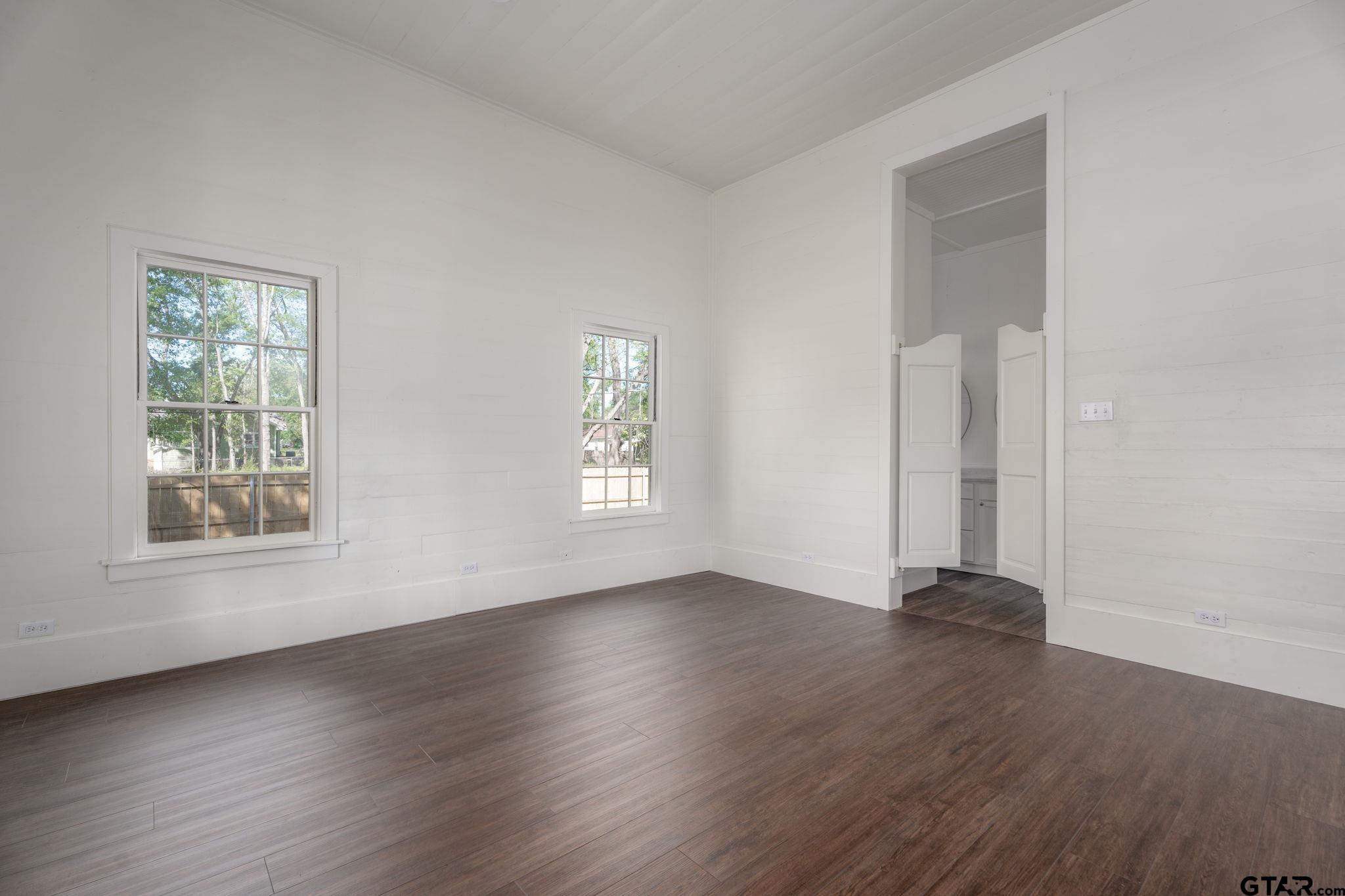 605 East Calvert Street Troup, TX 75789 - Photo 9 of 23 an empty room with wooden floor and windows