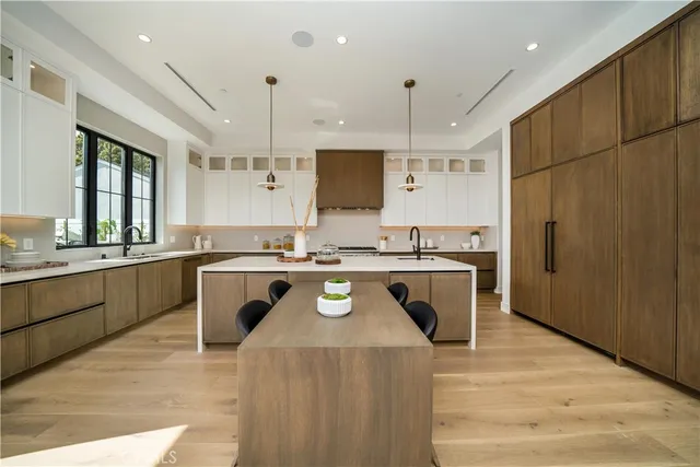 a kitchen with kitchen island granite countertop a sink a counter top space stainless steel appliances and cabinets