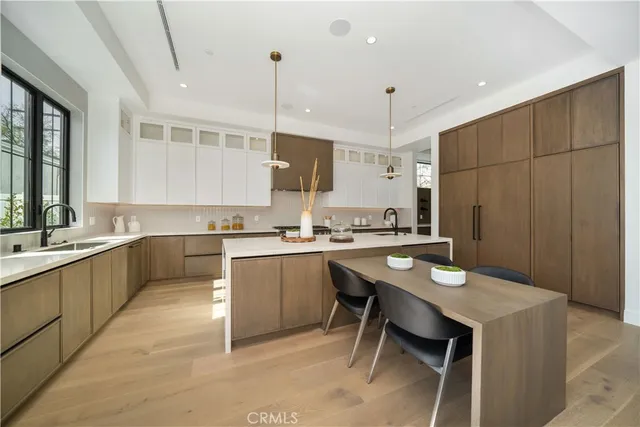 a kitchen with a sink refrigerator and chairs