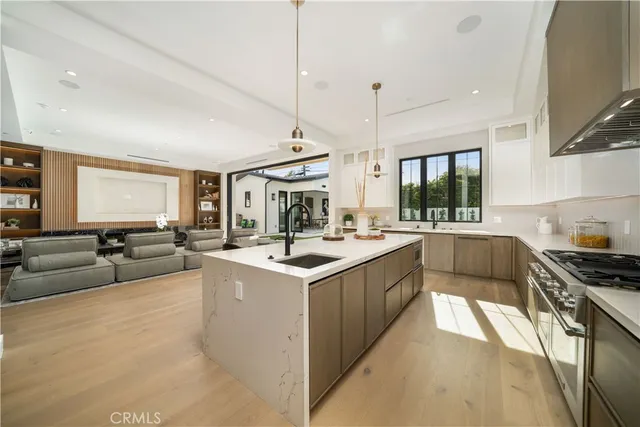 a kitchen with stainless steel appliances granite countertop a sink a stove and a refrigerator