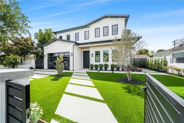 a front view of a house with swimming pool and yard with green space