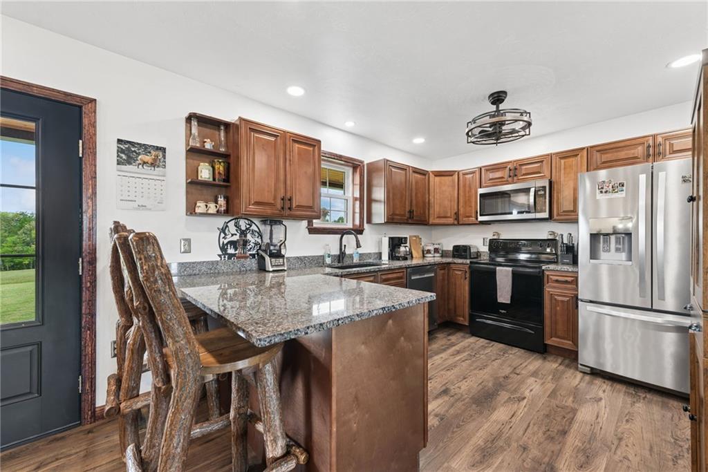 394 Mountain View Road New Florence, PA 15944 - Photo 12 of 37 a kitchen with stainless steel appliances granite countertop a refrigerator a stove a sink a dining table and chairs