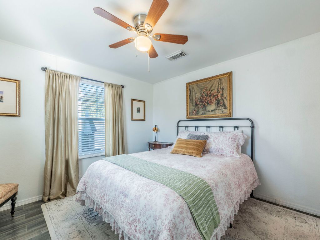 11012 3rd Street Jonestown, TX 78645 - Photo 11 of 26 a bedroom with a large bed and a chandelier