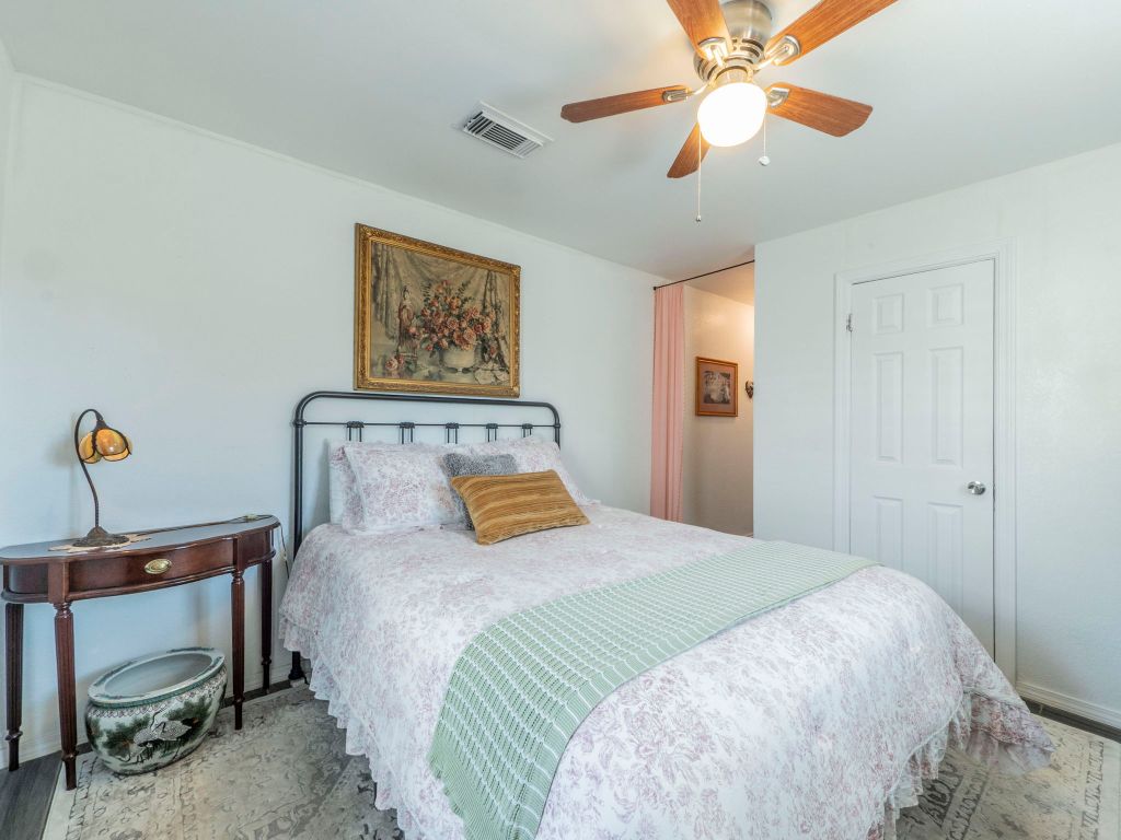 11012 3rd Street Jonestown, TX 78645 - Photo 12 of 26 a bedroom with a bed and a chandelier