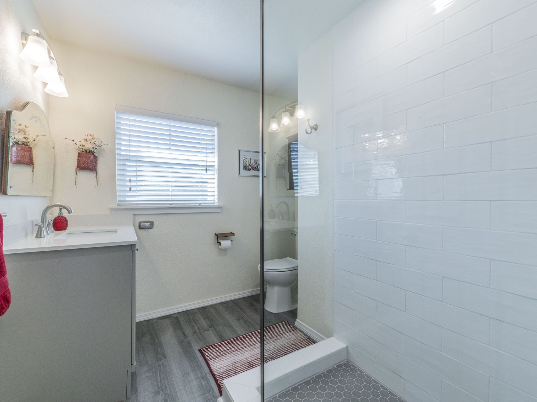 11012 3rd Street Jonestown, TX 78645 - Photo 14 of 26 The bathroom was just updated in 2024 and features new laminate flooring, updated vanity, fixtures, and cabinetry, and a new shower with glass enclosure.