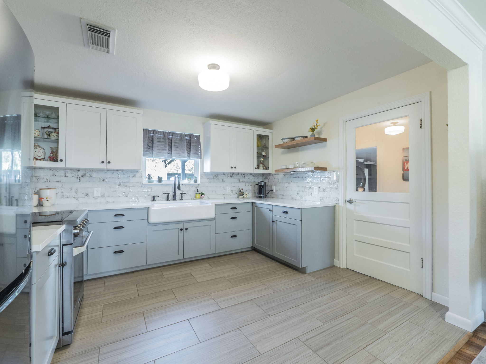 11012 3rd Street Jonestown, TX 78645 - Photo 8 of 26 The beautifully updated kitchen features white quartz countertops, custom cabinetry and shelving, a farmhouse sink, and stainless appliances.