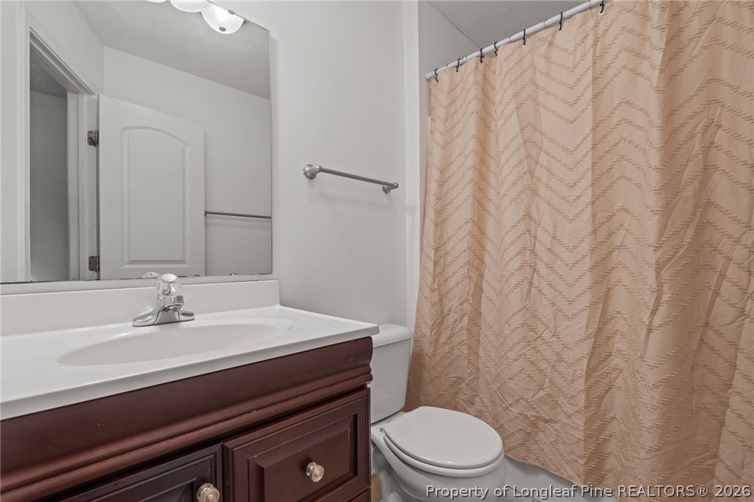 115 Shelby Street Spring Lake, NC 28390 - Photo 31 of 40 a bathroom with a sink a toilet and a mirror