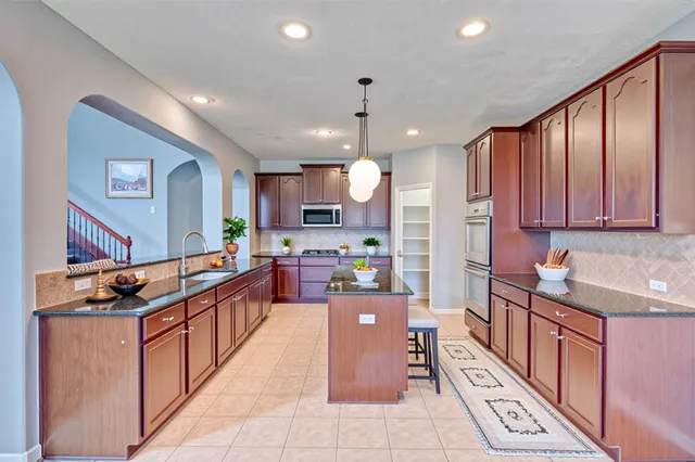 a kitchen with stainless steel appliances kitchen island granite countertop a sink and cabinets