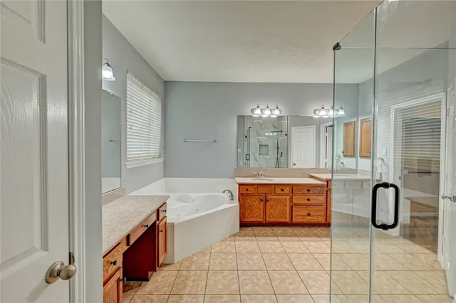 a spacious bathroom with a tub sink and mirror