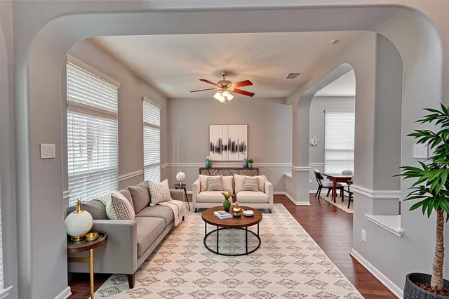 a living room with furniture potted plant and a large window