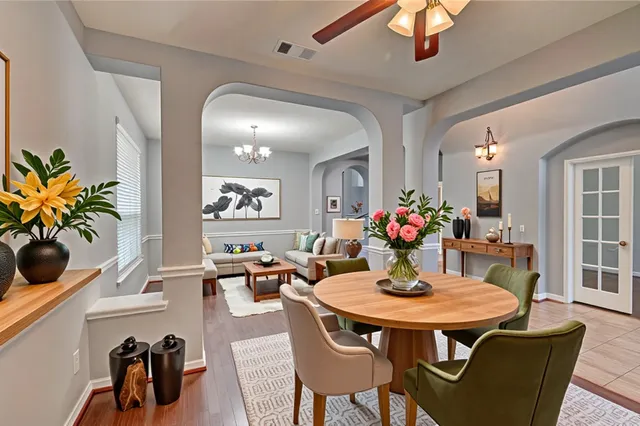 a dining room with furniture potted plants and wooden floor