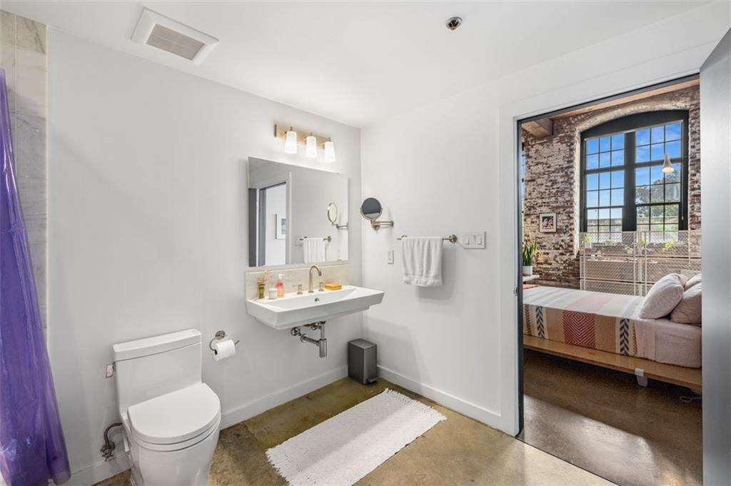 170 Boulevard Southeast, Unit 211H Atlanta, GA 30312 - Photo 23 of 49 a bathroom with a toilet sink and mirror