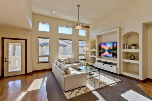 a living room with furniture a flat screen tv and a floor to ceiling window
