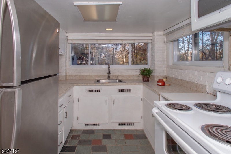 18 Decker Pond Road Vernon, NJ 07461 - Photo 28 of 40 a kitchen with a stove and white cabinets