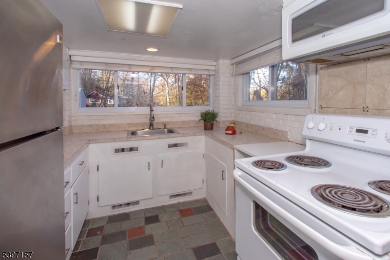 18 Decker Pond Road Vernon, NJ 07461 - Photo 29 of 40 a kitchen with a stove a sink and a refrigerator