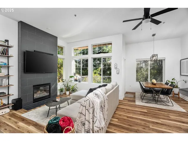 a living room with furniture a flat screen tv and a fireplace