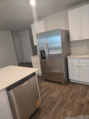 a kitchen with stainless steel appliances a refrigerator and a stove top oven
