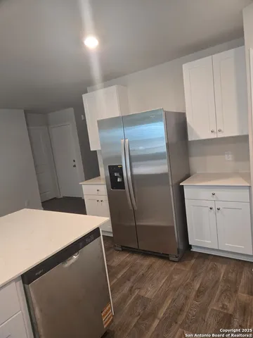 a kitchen with a refrigerator sink and cabinets