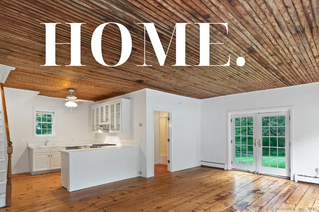 a view of a kitchen with stainless steel appliances wooden floor and a large window