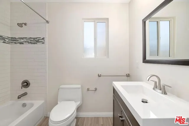 a bathroom with a toilet a sink a mirror a bathtub and shower