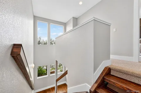 a view of a patio with couches plants and wooden fence