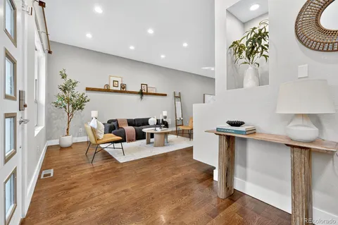 a living room with furniture and a wooden floor