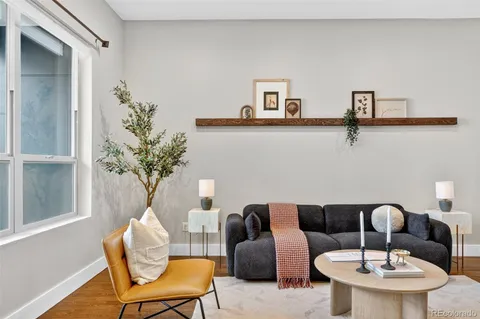 a dining area with stainless steel appliances a dining table wooden floor and a large window