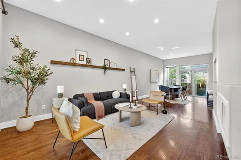 a kitchen with stainless steel appliances granite countertop a refrigerator a sink a stove a dining table and chairs