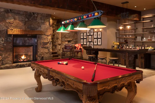 a room with pool table table and a fireplace
