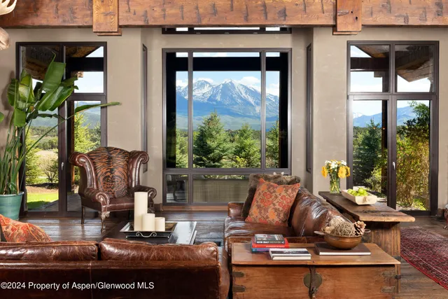 a living room with fireplace furniture and a floor to ceiling window