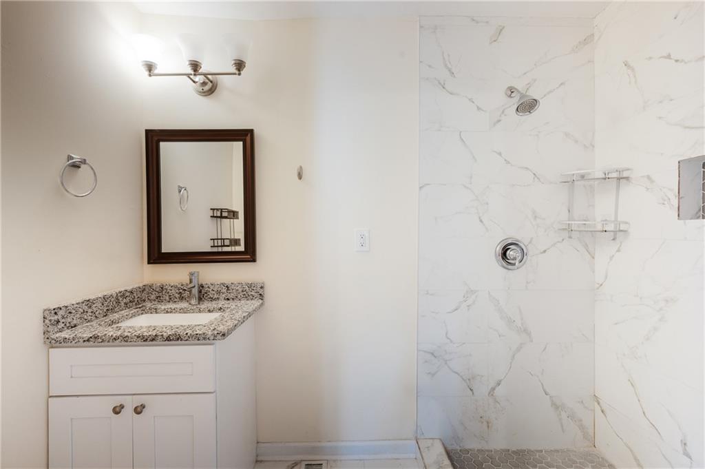 5287 Maple Valley Road Southwest Mableton, GA 30126 - Photo 14 of 29 a bathroom with a granite countertop sink a mirror and shower
