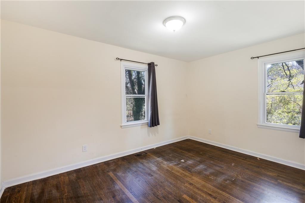 5287 Maple Valley Road Southwest Mableton, GA 30126 - Photo 16 of 29 an empty room with wooden floor and windows