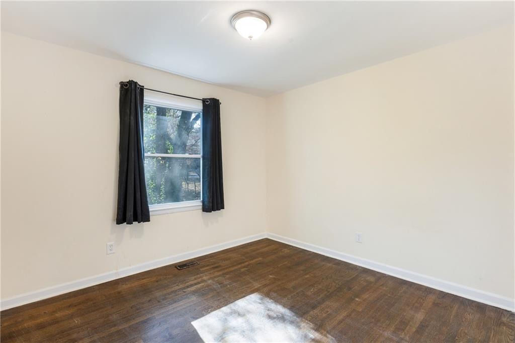 5287 Maple Valley Road Southwest Mableton, GA 30126 - Photo 17 of 29 an empty room with wooden floor and windows