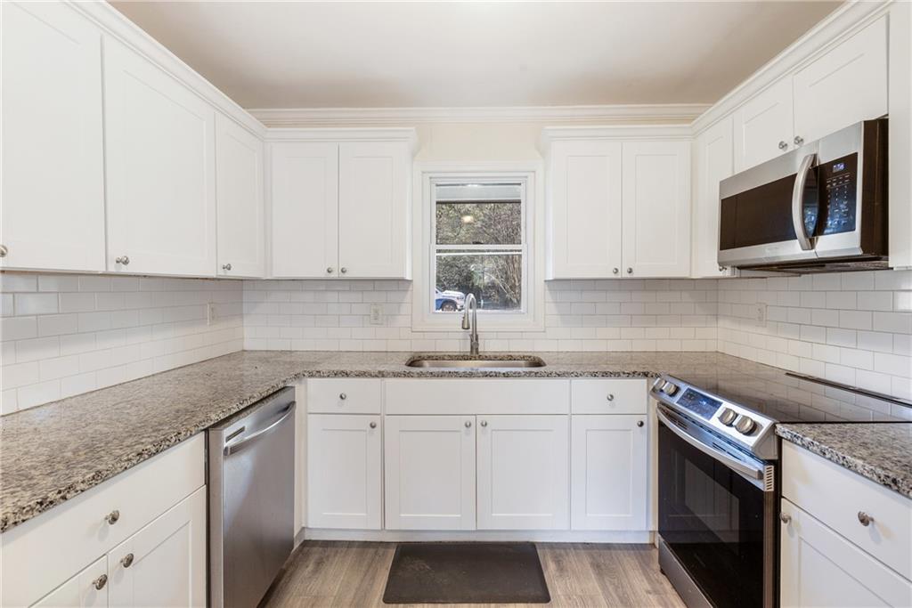 5287 Maple Valley Road Southwest Mableton, GA 30126 - Photo 7 of 29 a kitchen with stainless steel appliances granite countertop white cabinets granite counter tops and a stove