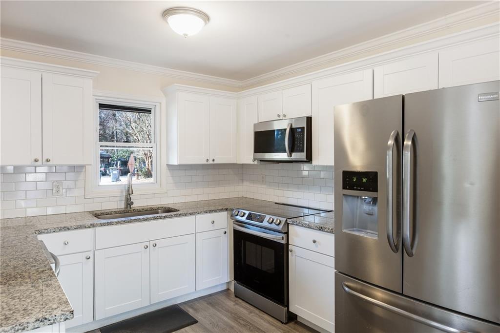 5287 Maple Valley Road Southwest Mableton, GA 30126 - Photo 8 of 29 a kitchen with stainless steel appliances white cabinets and a sink