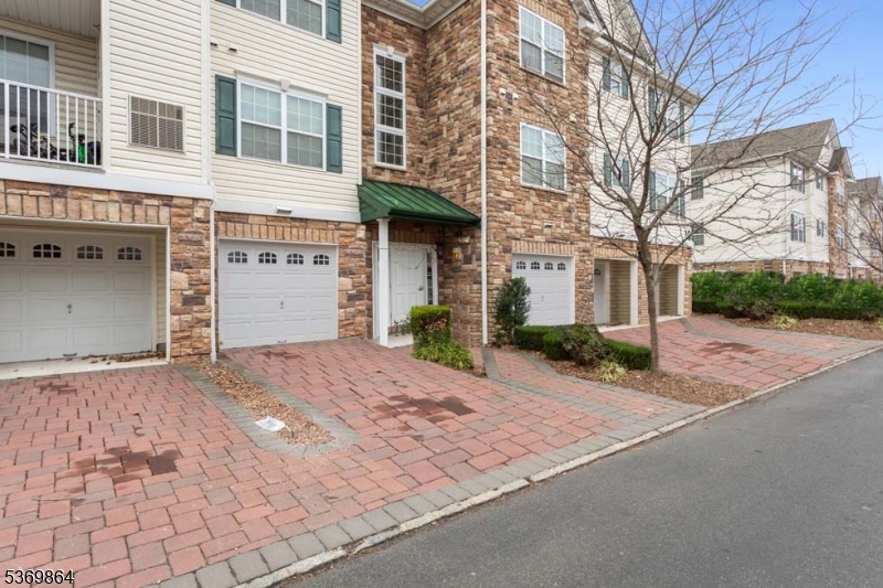 a front view of a building with a yard and garage