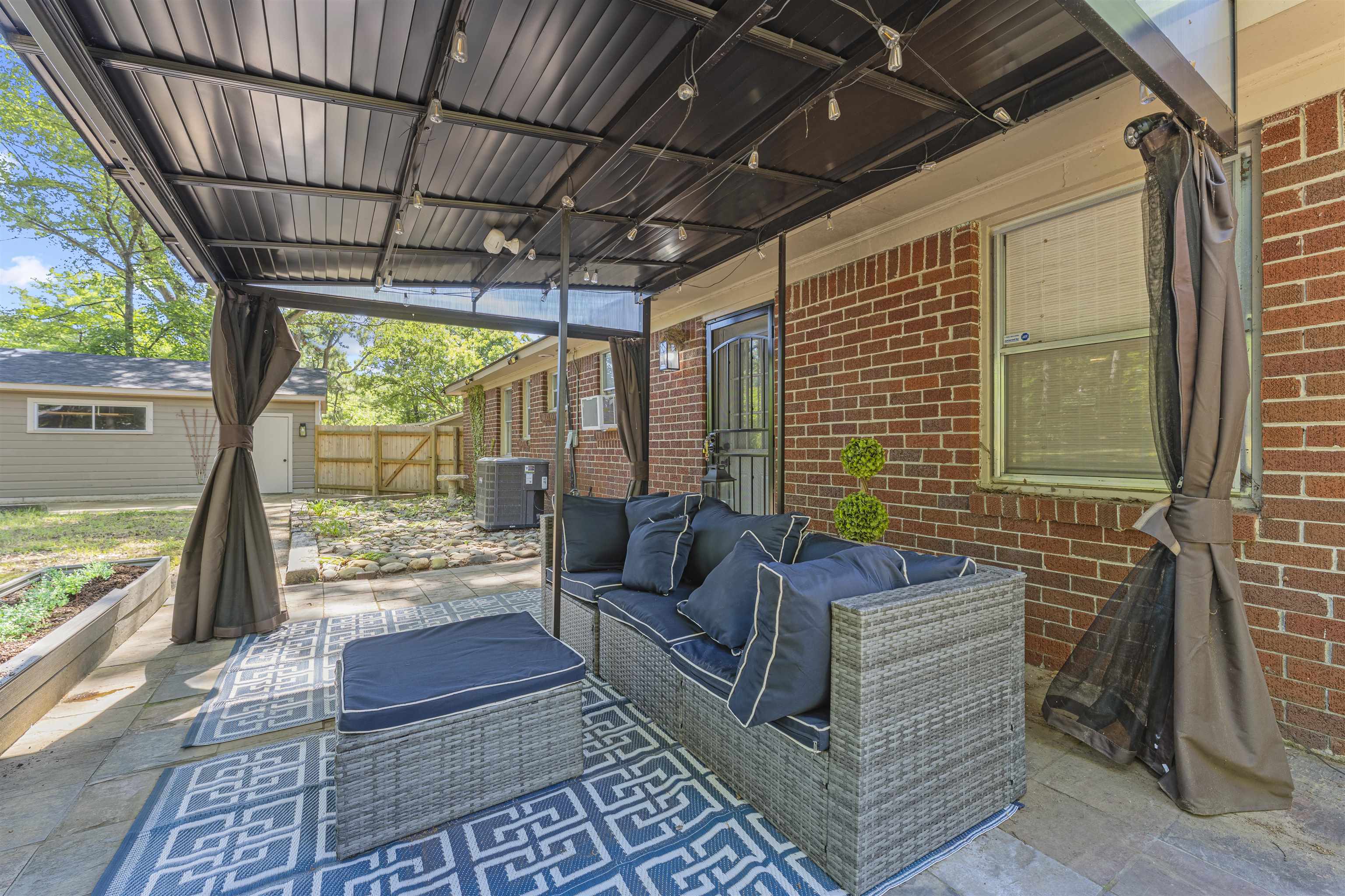 5271 Princeton Road Memphis, TN 38120 - Photo 29 of 30 Expansive patio featuring a permanent pergola structure, brick exterior, and a raised planter bed